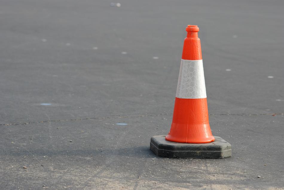 striped traffic cone on asphalt
