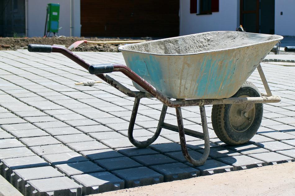 Old wheelbarrow with blue paint, near the building