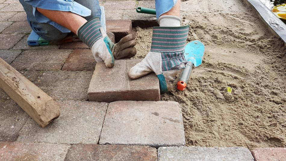 Worker, making the colorful pavement, with the tools