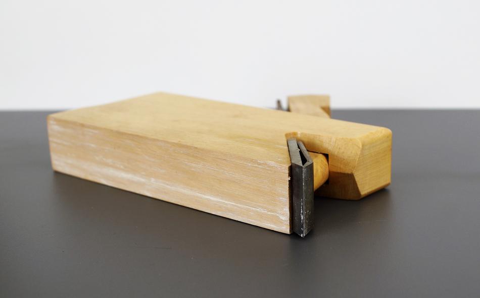 Close-up of the wood planer, on the black surface