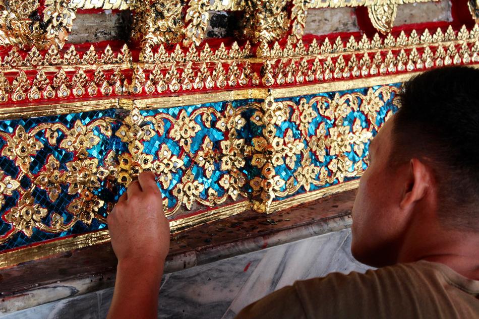 Man, investigating the beautiful, gold, blue and red, ornamental mosaic