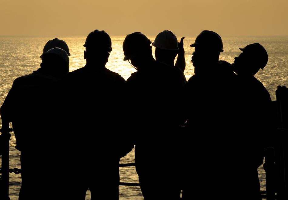 Black silhouettes of the sailors, on the beautiful ship view at colorful sunset