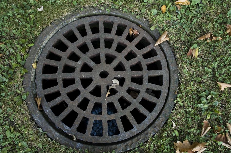 Sewer Cover Iron on green grass close up