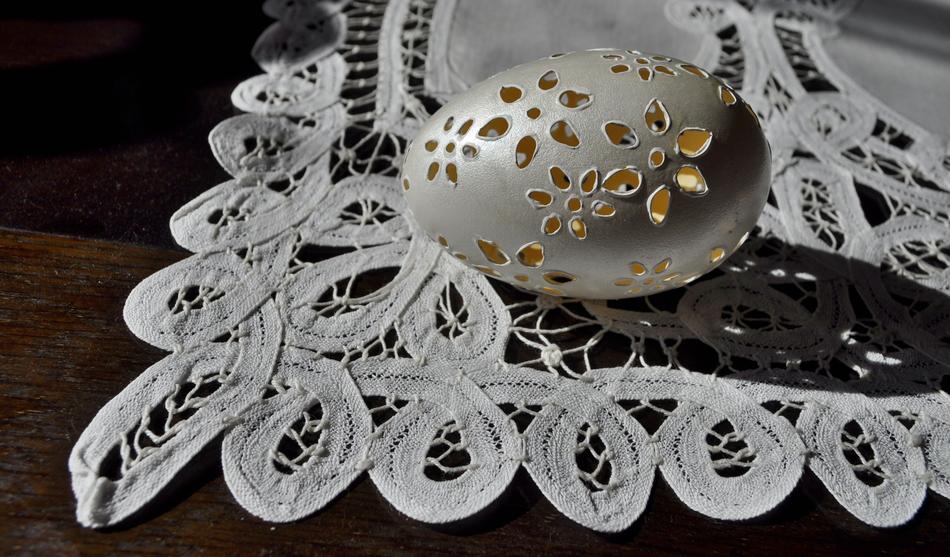 Beautiful, decorated, white Easter egg, on the beautiful, white decorated tablecloth