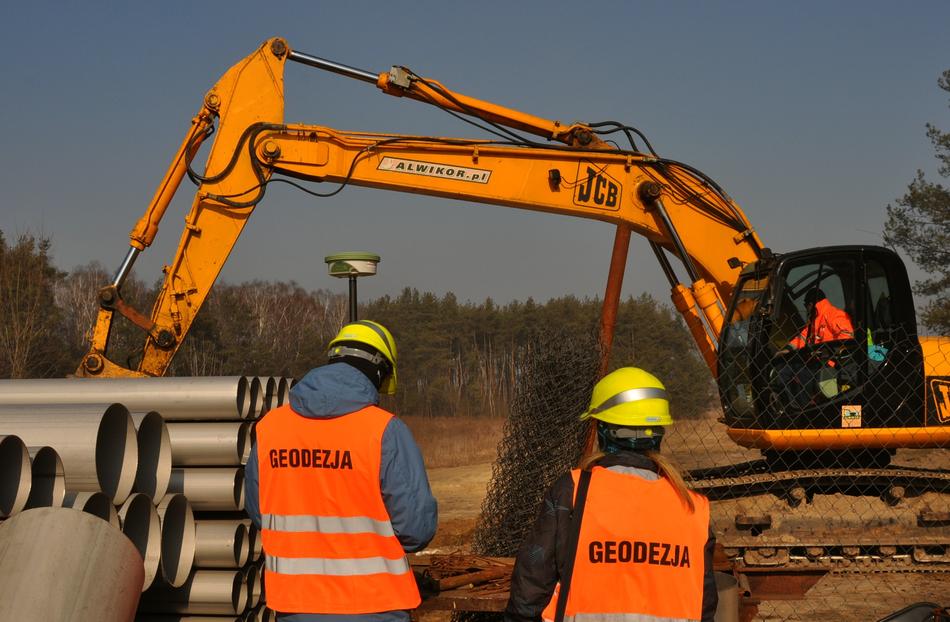 Workers in equipment, near the excavator, near the colorful trees