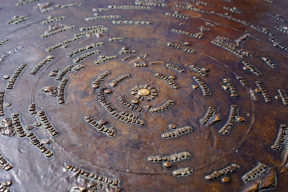 round bronze information board in the Alps
