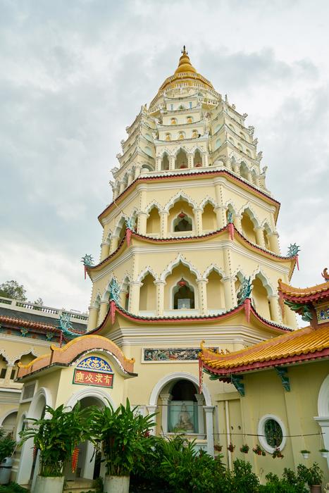 Beautiful and colorful temple tower, with the green plants, under the sky, with the clouds