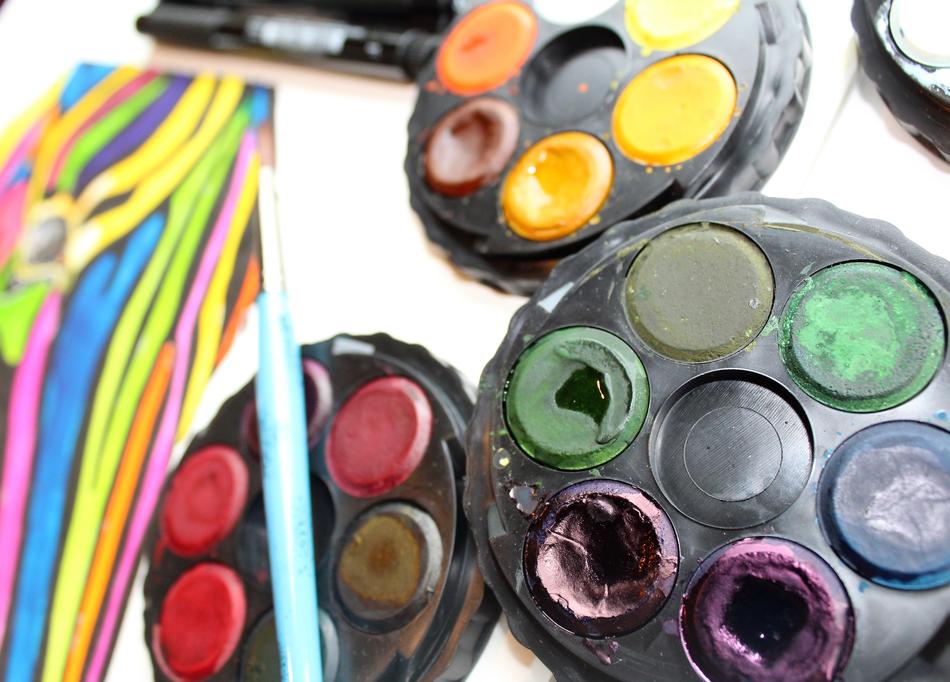 Colorful and beautiful paint on the palettes, in light, on the white surface