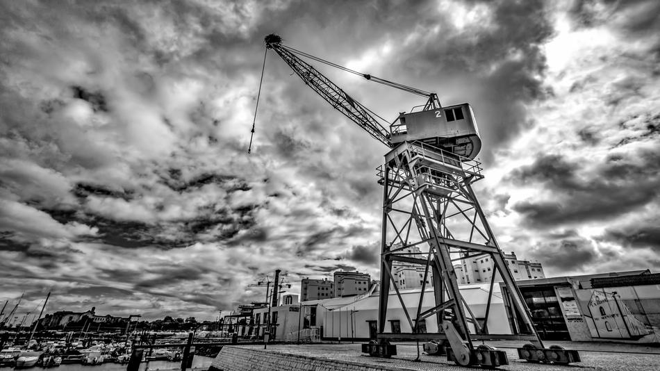 Black and white photo of the port of Portimao, Portugal, with the crane