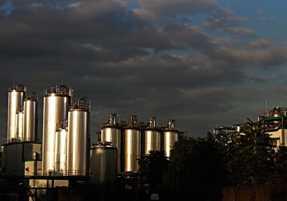 Shiny metal silos, on the landscape, under the blue sky with clouds