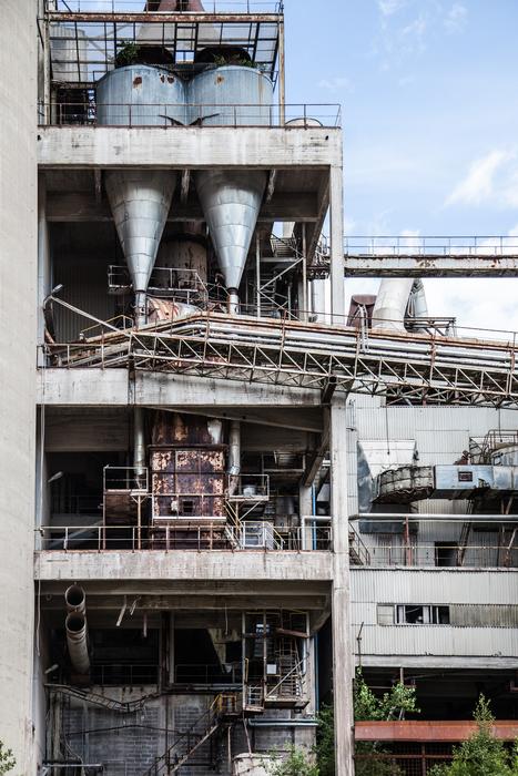 Construction of the factory, with the machines, at blue sky with white clouds on background