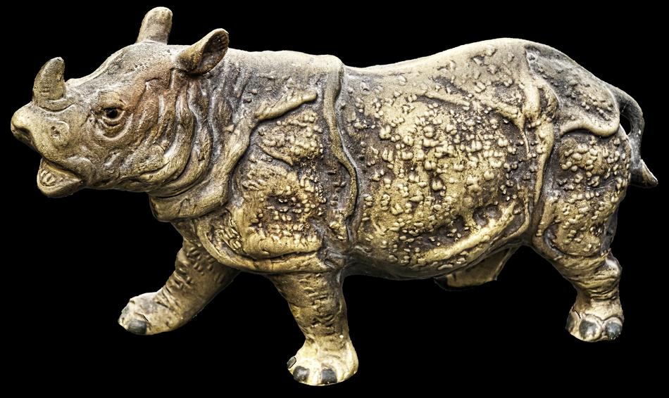 ceramic figurine of a rhinoceros on a black background