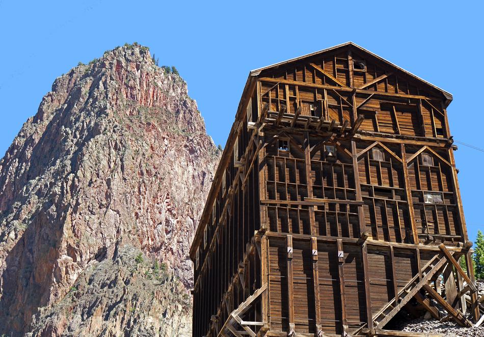 Beautiful, wooden mine building near the mountain, at blue sky on background