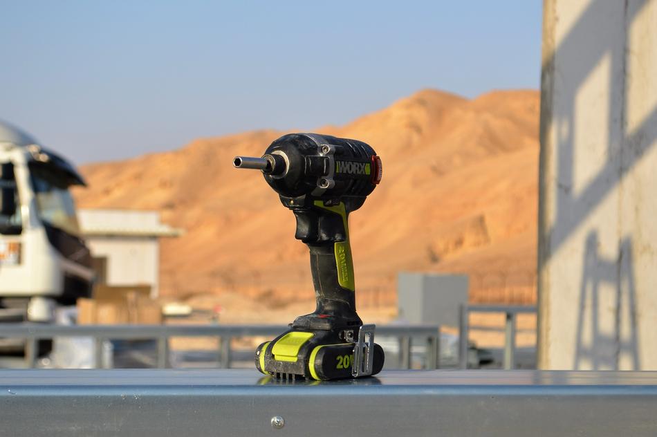 Close-up of the yellow and black drilling machine, at background with beautiful, yellow mountains