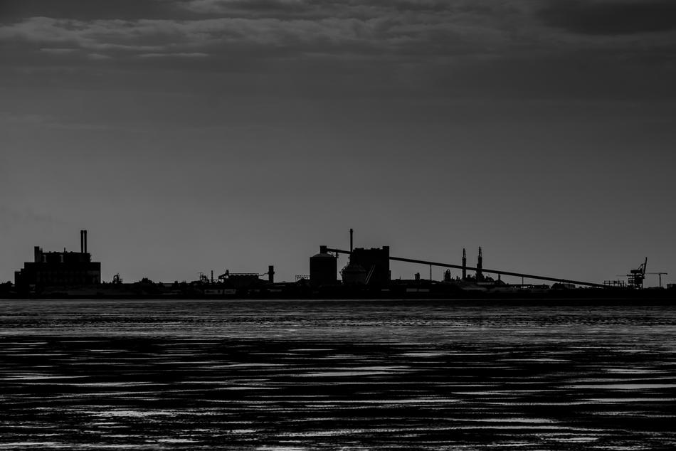 Black and white photo with the industrial buildings, on the shore