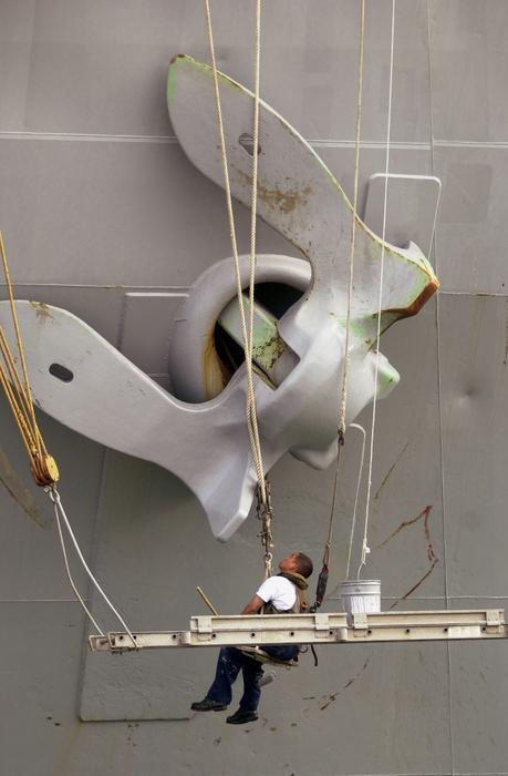 Close-up of the man, near the anchor of the ship