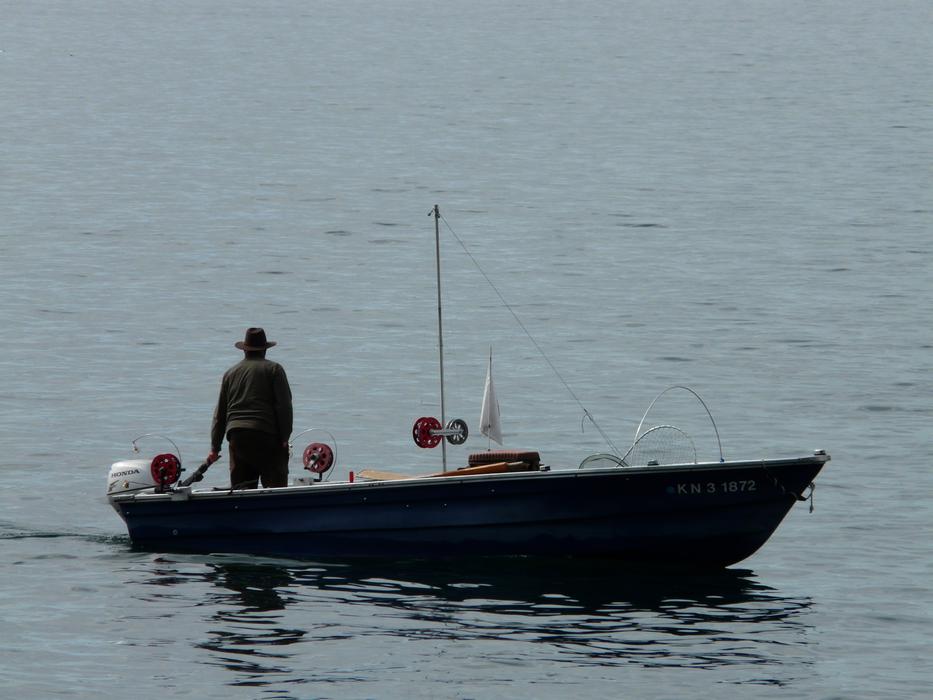 Fisherman on the fishing boat, on the beautiful waterscape