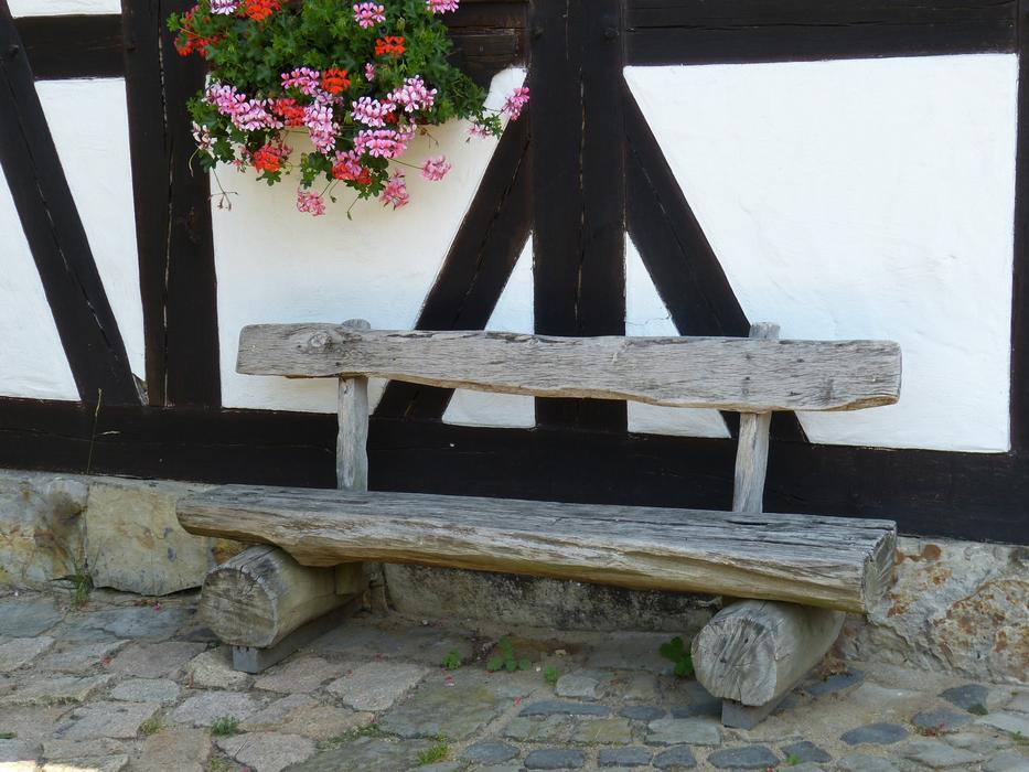 wooden bench against the background of the facade of the fachwerkhaus
