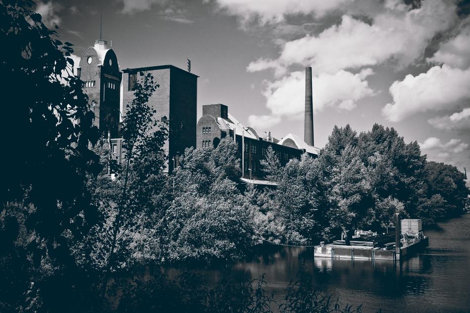 Black and white photo of the factory, among the trees in the port DÃ¼sseldorf, Germany
