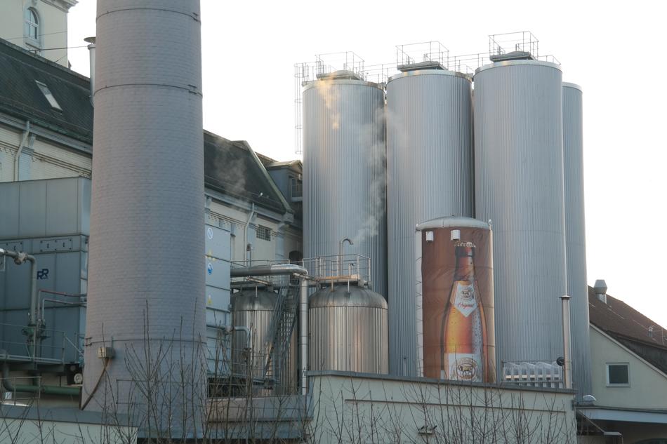 Landscape of the brewery plant with silos, at beautiful, white sky on background