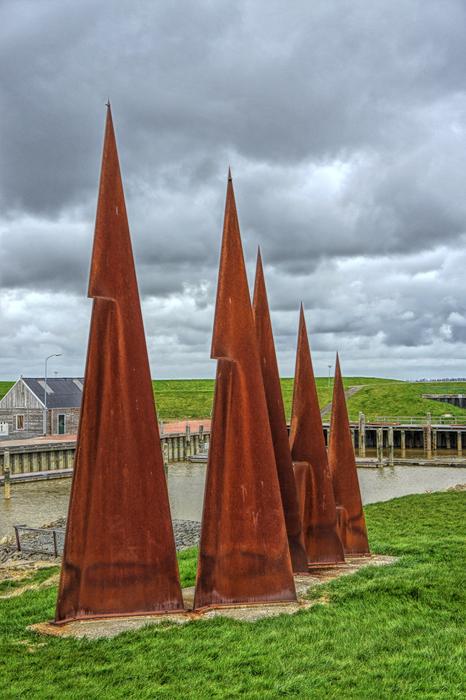 Beautiful landscape with the rust steeples, on the green field, under cloudy sky, in the port