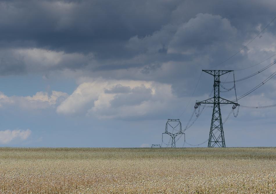 high voltage masts in the field on a cloudy day