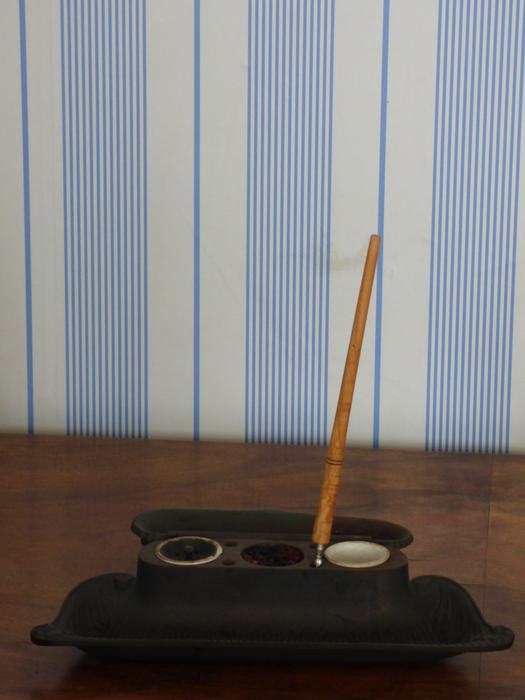 Stylus and paints near the blue and white wall with stripes