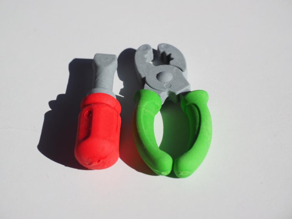 Close-up of the grey toy tools with red and green handles with shadows