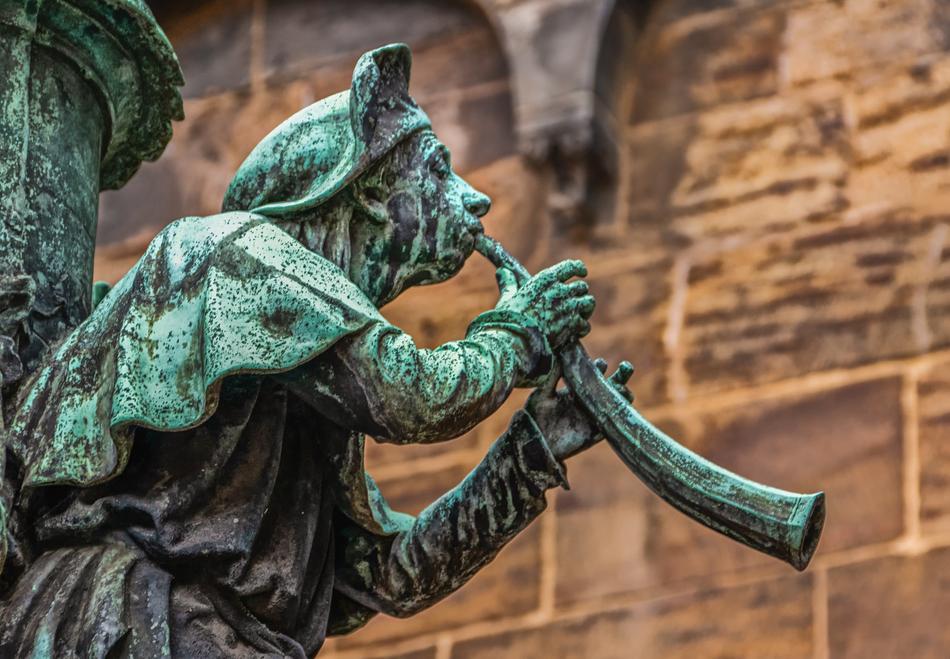 Old sculpture of the trumpeter, near the wall of the building