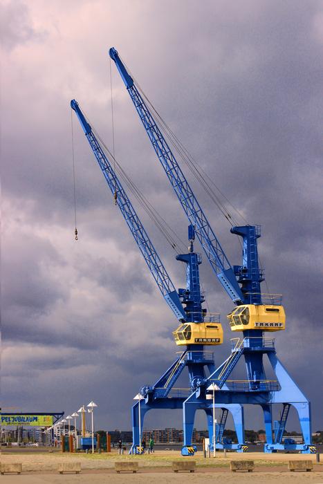 blue shipbuilding cranes on a cloudy day