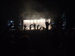 hands of the crowd in the dark at a concert