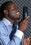 dark-skinned man sings in a museum studio
