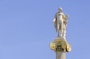 Apollo sculpture on column at sky in Greece, Athens