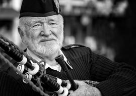 black and white photo of a scottish military with a bagpipe