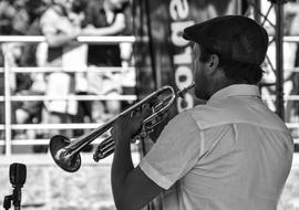 black and white photo of a musician with a trumpet at a street performance