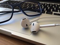 glasses and headphones are on the laptop keyboard