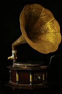 Close-up of the beautiful, shiny, gold, patterned gramophone, at black background