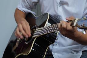 a musician in a suit plays the guitar