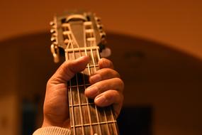 photo of hands on a guitar neck