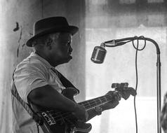 black and white photo of a musician with a hat near a microphone