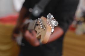 muddy photo of a guitar in the hands of a musician