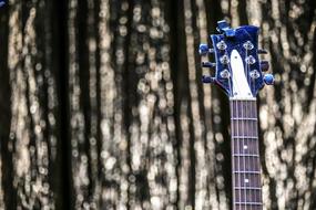 blue fretboard of electric guitar on blurred background