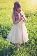 girl is playing flute on a green meadow