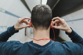 Back view of the guy with orange headphones