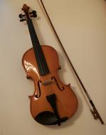 wooden violin hanging on a white wall