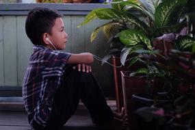 boy listens to music through headphones on the balcony