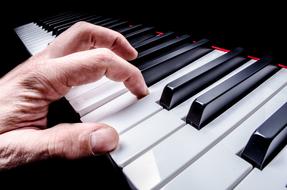 Person, playing on the beautiful, shiny, white and black keys of the piano