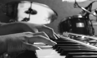 monochrome photo of musician's hands on piano keys