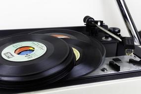 a stack of vinyl records lies on a gramophone