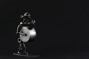 drummer as a metal figurine on dark